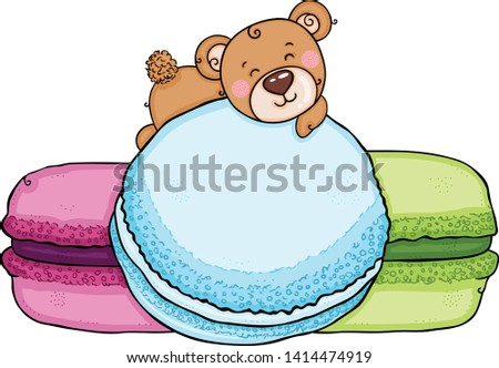 Little teddy bear lying on macarons
