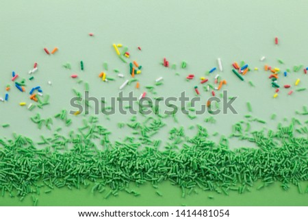 Green sprinkles on two tone green background with multi coloured sprinkles scattered - Green sprinkle background with space for text