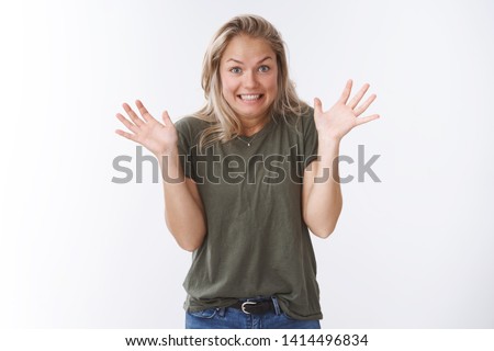 Yikes sorry. Studio shot of awkward cute blond woman raising palms in apology gesture smiling excusing for not making mistake on purpose posing guilty against white background Royalty-Free Stock Photo #1414496834