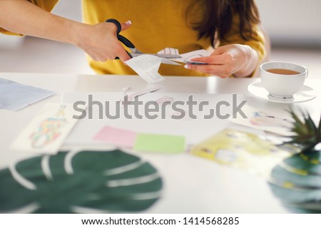 Young brunette woman creating her Feng Shui wish map using scissors Royalty-Free Stock Photo #1414568285