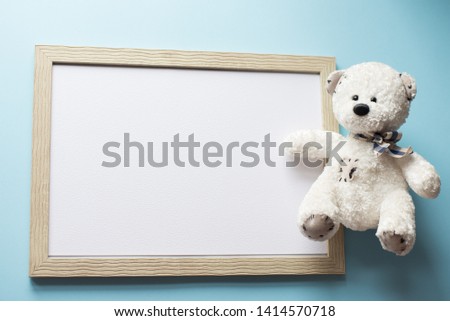 Baby , child frame and white teddy bear on blue background