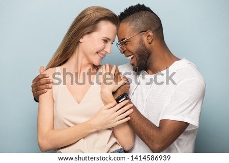 Happy overjoyed young african american man in eyeglasses embracing millennial smiling caucasian woman, touching foreheads, celebrating success, pregnancy notice, special family moments, anniversary.