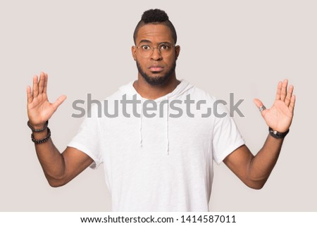 Stunned funny black 30s man in glasses gawp at camera stretched hands showing something huge feels shocked pose isolated on grey studio background, large big size gesture of exaggerating concept image Royalty-Free Stock Photo #1414587011
