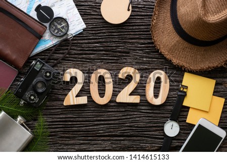 top view 2020 happy new year number on wood table with adventure accessory item,holiday vacation planning