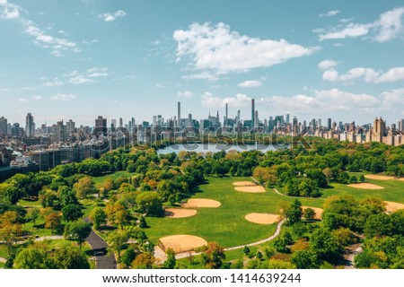 Aerial view of the Central park in New York with golf fields and tall skyscrapers surrounding the park.