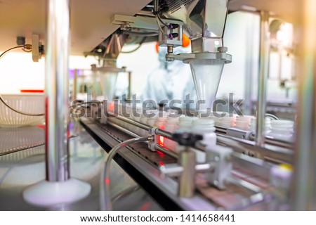 Transfer medicine bottles on the conveyor belt in the pharmaceutical industry, industrial machinery for the quality of medical products. Industrial concept and factory technology.shallow focus effect. Royalty-Free Stock Photo #1414658441