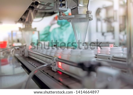 Transfer medicine bottles on the conveyor belt in the pharmaceutical industry, industrial machinery for the quality of medical products. Industrial concept and factory technology.shallow focus effect. Royalty-Free Stock Photo #1414664897