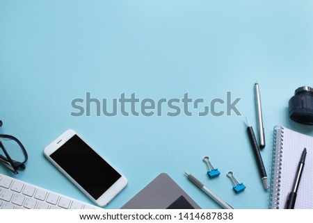 Office desk working space - Flat lay top view mockup photo of working space with laptop, smartphone and notebook on blue pastel background. Pastel blue color background working desk concept