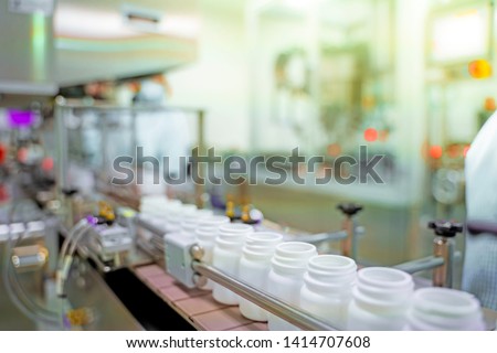 Transfer medicine bottles on the conveyor belt in the pharmaceutical industry, industrial machinery for the quality of medical products. Industrial concept and factory technology.shallow focus effect. Royalty-Free Stock Photo #1414707608