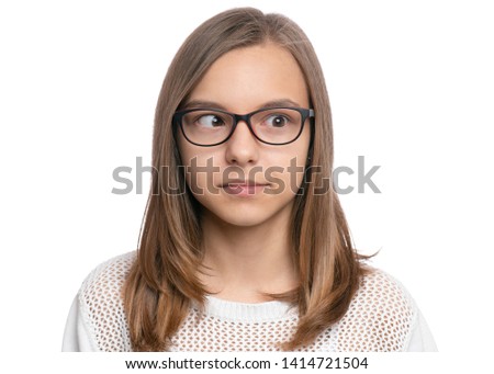 Crazy child making grimace - Silly face. Funny caucasian teen girl in eyeglasses, isolated on white background. Close-up portrait.
