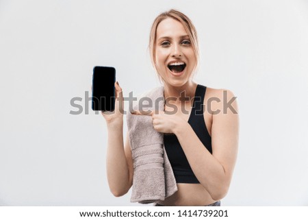 Image of pretty blond woman 20s dressed in sportswear with towel over neck using smartphone during workout in gym isolated over white wall