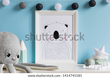 Cozy scandinavian newborn baby room with mock up poster frame, plush octopus ,mint crayon, boxes and children accessories. Stylish interior with blue walls and haniging cotton balls . Template.