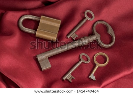 Keys and lock on red background