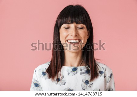 Image of a beautiful happy young woman posing isolated over pink wall background.