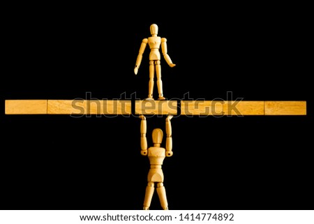 Human figure standing and support the other one by wooden block. Business support ,teamwork and team spirit concept.
 