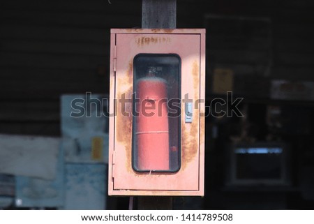 Old Red Fire extinguisher in the red box.