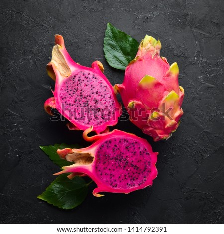 Red Pitahaya on a black background. Fruit Dragon. Tropical Fruits. Top view. Free space for text.