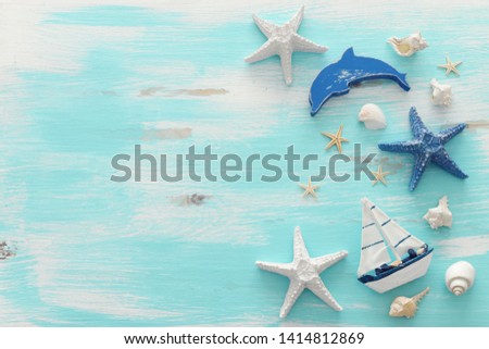vacation and summer concept with vintage boat, starfish and seashells over pastel blue wooden background. Top view flat lay