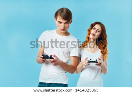 Cute young couple with gamepads in the hands of a video game console console fun hobby