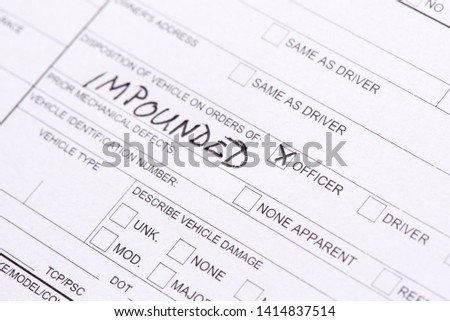 A close up of a traffic collision report with the word "impounded" written on it.  Royalty-Free Stock Photo #1414837514