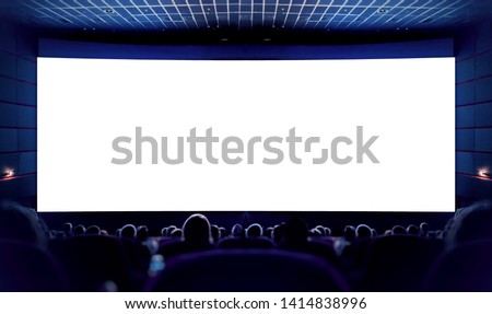 Cinema. White screen in the cinema and the audience watching the movie. Royalty-Free Stock Photo #1414838996