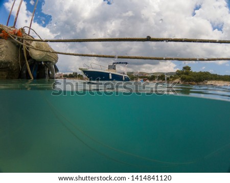 boat picture in ksamil albania showing the blue and white boat and the old deck with ropes . 