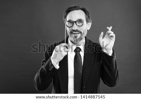Hipster or nerd. Man holds party props eyeglasses. Boss or businessman wear formal suit posing party accessory. Business strategy. Business party invitation. Business conference and entertainment.
