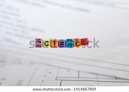 The inscription "Science" of multi-colored letters on the background of scientific and technical drawings and records.