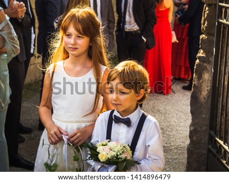 Ring bearer and flower girl at summer wedding near church. Italy Royalty-Free Stock Photo #1414896479