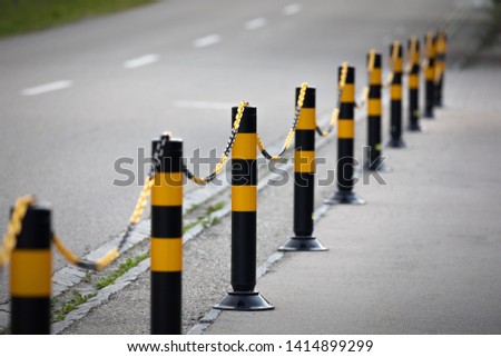 yellow-black barrier at the roadside, depth of field