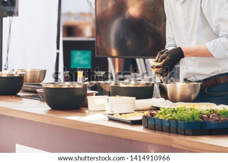 Cook prepares food on a demo advertisement. Royalty-Free Stock Photo #1414910966