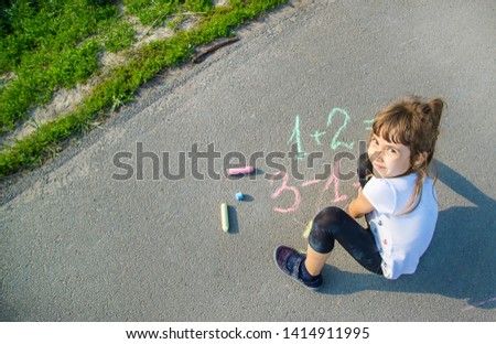 The child decides grunts on the asphalt. Selective focus. nature.