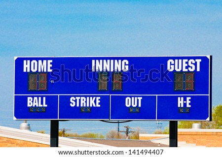 Baseball scoreboard with blue skky in the background.