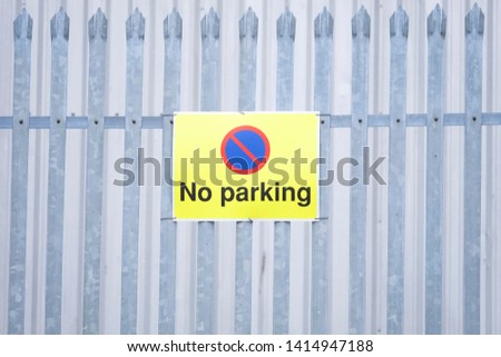 No parking yellow sign on private fence