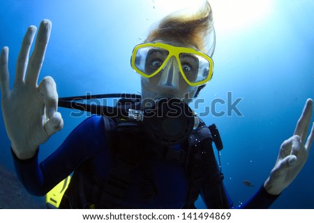 Crazy diver showing ok signal with bulging eyes