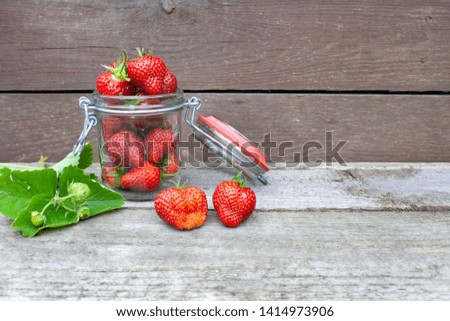 A jar filled with red, ripe strawberries