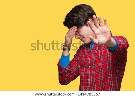 Young handsome man wearing glasses over isolated background covering eyes with hands and doing stop gesture with sad and fear expression. Embarrassed and negative concept.