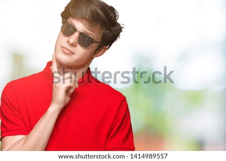 Young handsome man wearing sunglasses over isolated background with hand on chin thinking about question, pensive expression. Smiling with thoughtful face. Doubt concept.