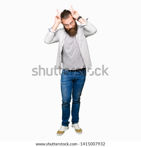 Young blond man wearing glasses Posing funny and crazy with fingers on head as bunny ears, smiling cheerful