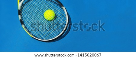 Classic Blue color of the 2020 year. Summer sport concept with tennis ball and racket on blue hard tennis court. Flat lay, top view, copy space. Blue and yellow. Royalty-Free Stock Photo #1415020067