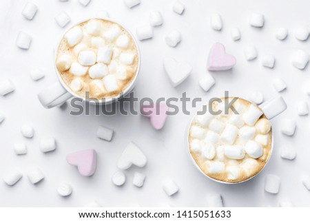 Romantic cozy desk top with two cups of coffee with marshmallows on marble table. Top view.