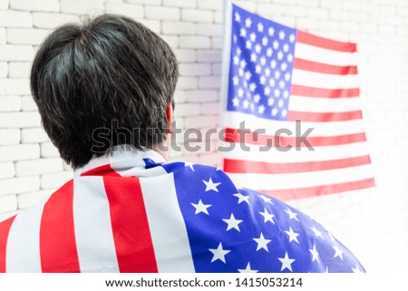 Guy is wrapped in the flag of America celebrating American Independent Day - independence day and people concept. 