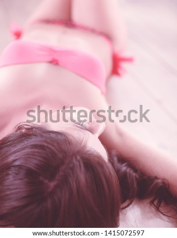 Beautiful young woman in bikini standing lying on beach