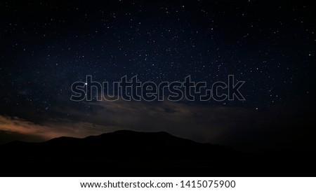 Beautiful night sky in the Utah desert on a summer night with a mountain in the background.