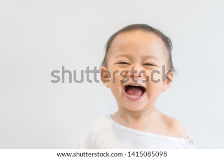 Happy Little asian baby boy child showing front teeth with big smile and laughing in white : Healthy happy funny smiling face young adorable lovely kid.Joyful portrait of asian elementary preschool.