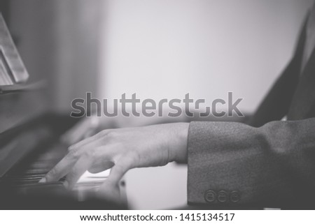 Man hands on grand piano for worship in Church.Male pianist Playing classic piano.Professional musician pianist hands on piano keys.black and white tone.