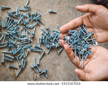 worker counting screws by hands and package in clear plastic bag