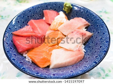 Fresh raw seafood mixed rice bowl (Kaisen-don/ Japanese tasty food), Japanese Rice with sashimi of tuna, Maguro, Otoro and salmon with wasabi in a ceramic bowl