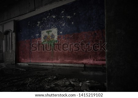 painted flag of haiti on the dirty old wall in an abandoned ruined house. concept
