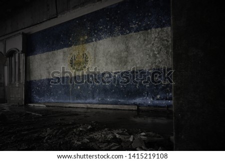 painted flag of el salvador on the dirty old wall in an abandoned ruined house. concept